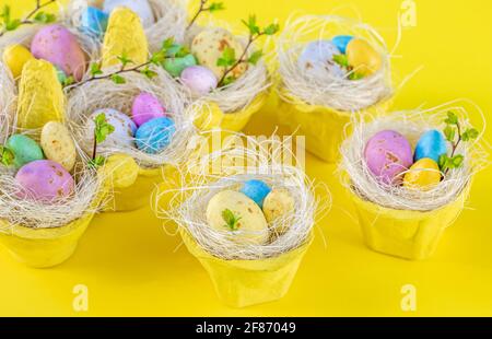 Happy Easter concept. Bright yellow Easter card. Sweet bright Easter eggs in the nests Stock Photo