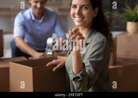 Cropped close up smiling woman holding keys, family relocation concept Stock Photo