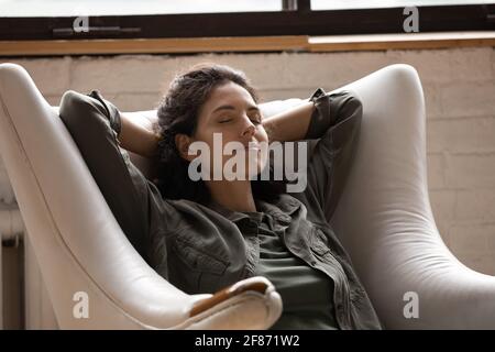 Close up relaxed woman with closed eyes sitting in armchair Stock Photo