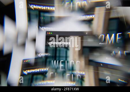 Milan, Italy - APRIL 10, 2021: CrowdStrike logo on laptop screen seen through an optical prism. Illustrative editorial image from CrowdStrike website. Stock Photo