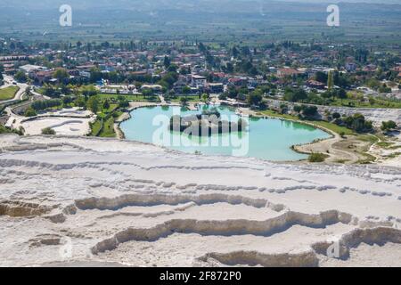 Panoramic view onto travertine terraces, artificial lake & town Pamukkale, Turkey. Terraces included in UNESCO List
