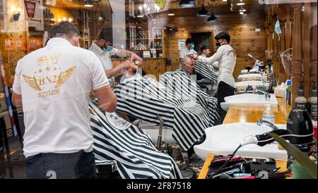 Brighton UK 12th April 2021 - It's good to get a close shave and haircut in Brighton this morning as the next stage of lockdown easing begins in England with non essential shops and businesses opening up for the first time in months : Credit Simon Dack / Alamy Live News Stock Photo