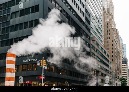 New York City, USA - June 24, 2018: Steam coming out stack for venting the district heating system in Midtown of New York. Climate Change and Carbon F Stock Photo