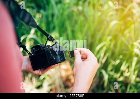 Photographer inserting the memory card into the camera Stock Photo