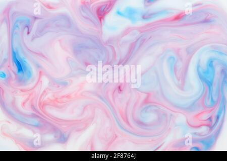 Swirling artistic blend of blue and pink ink in an abstract background pattern and texture for use as a design template in a full frame view Stock Photo