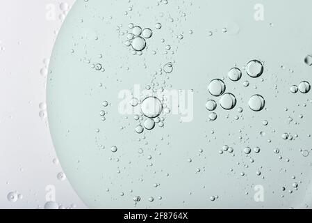 Circular oil bubbles or globules on the surface of a clear transparent liquid viewed from above in a random abstract pattern in a full frame view for Stock Photo