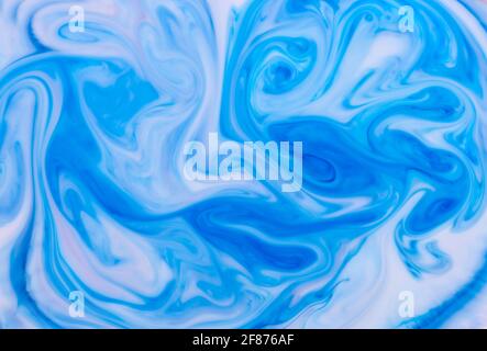 Abstract background of swirling blue waves of ink in water forming an artistic flowing monochromatic pattern for use as a design template Stock Photo