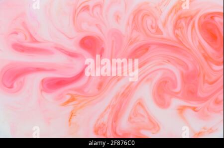 Abstract background pattern and texture of swirling pink ink creating a flowing wavy fluid effect in full frame for use as a design template Stock Photo