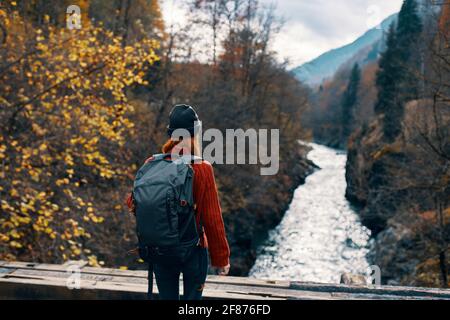 woman tourist stands on the bridge over the river or admires the nature landscape Stock Photo