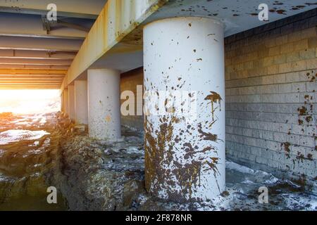 Spray dirt on poles under the bridge on an impassable road Stock Photo
