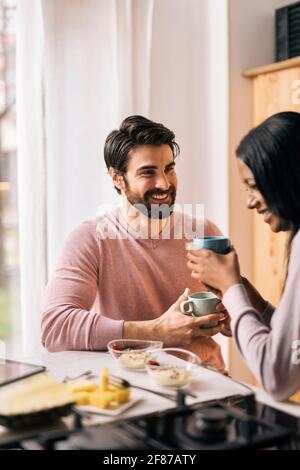 Handsome man and her girlfriend having breakfast in the kitchen at home. Stock Photo