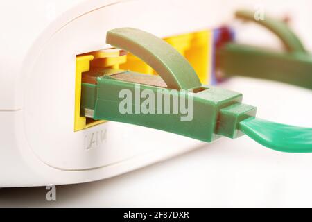 Macro photo of the internet connection with Ethernet RJ45 cable plugged to lan port of the wireless wi-fi router. Stock Photo