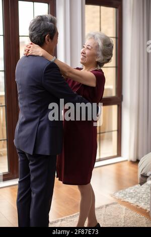 Happy senior couple embracing in bedroom Stock Photo