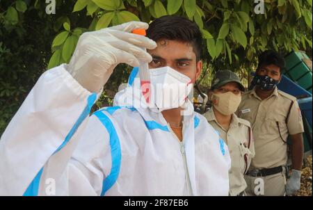 New Delhi, India. 12th Apr, 2021. A healthcare worker wearing a personal protective equipment (PPE) holds a mouth swab sample vial after Covid-19 Reverse Transcription Polymerase Chain Reaction (RT-PCR) test at the road side testing centre Wazzirpur industrial area in New Delhi. India registered 168,912 new Covid-19 cases, the highest single-day spike and 904 deaths in the last 24 hours. Credit: SOPA Images Limited/Alamy Live News Stock Photo