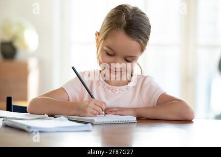 Cute little girl child do homework alone Stock Photo