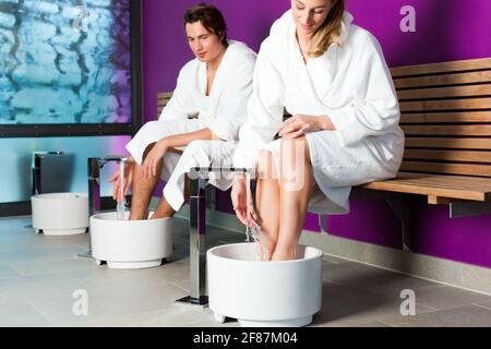 Couple - man and woman - having hydrotherapy water footbath in spa setting Stock Photo