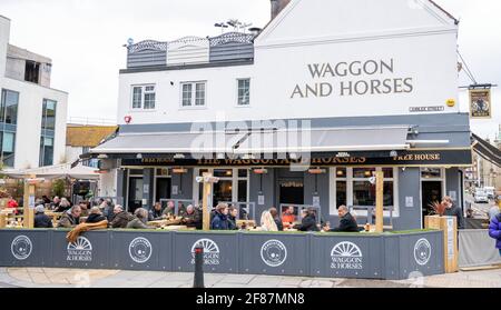Brighton UK 12th April 2021 - Visitors enjoy drinking outside the Waggon and Horses pub in Brighton as the next stage of lockdown easing begins in England with hospitality venues being allowed to serve outdoors : Credit Simon Dack / Alamy Live News Stock Photo