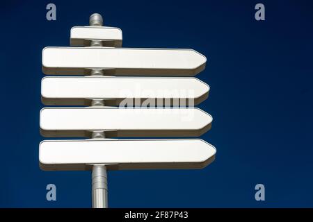 Blank directional road signs against blue sky. Directional sign post ...