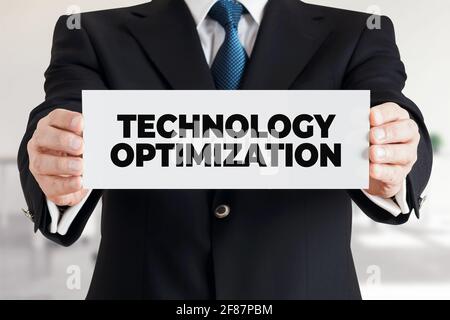 Businessman shows a banner with the message technology optimization. Business technology concept. Stock Photo
