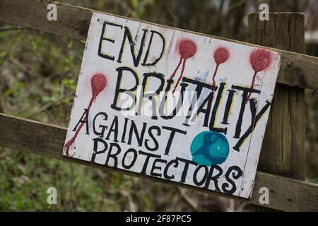 Wendover, UK. 9th April, 2021. A sign reading End Brutality Against Protectors is pictured outside Wendover Active Resistance Camp, which is occupied by activists opposed to the HS2 high-speed rail link. Tree felling work for the project is now taking place at several locations between Great Missenden and Wendover in the Chilterns AONB, including directly opposite the camp. Credit: Mark Kerrison/Alamy Live News