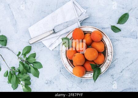 Apricots on plate with knife on concrete background top view Stock Photo