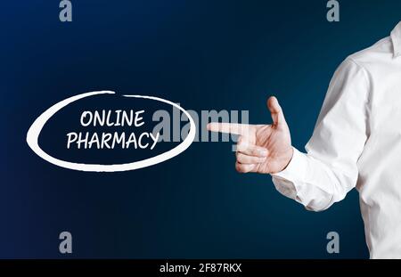 Male hand points to the word online pharmacy with an outline circle on blue background. Technology, internet and networking in medicine concept Stock Photo