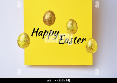 Golden shiny eggs and yellow blank with text - Happy Easter. Easter concept Stock Photo