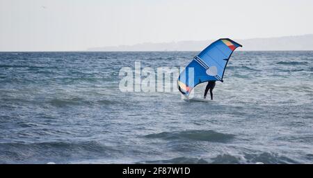 Man practicing with hydrofoil at sunset in the sea Stock Photo