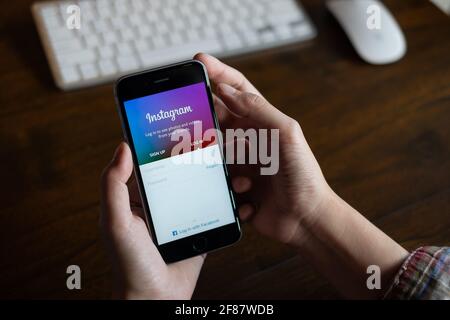 CHIANG MAI, THAILAND - FEB 26, 2020: A woman hand holding iphone with login screen of instagram application. Instagram is largest and most popular Stock Photo