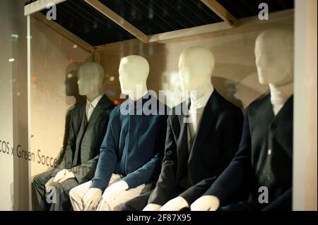 Male mannequins in fine retail shop window, shot at night. Smart wear trends in Central London, UK. Sep 2012 Stock Photo