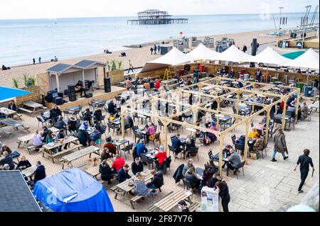 Brighton, UK. 12th Apr, 2021. Cheers, Brighton seafront bars are busy as the next stage of lockdown easing begins in England with non essential shops and hospitality businesses being allowed to reopen outdoors : Credit: Simon Dack/Alamy Live News Stock Photo