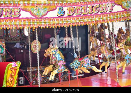 Brighton, UK. 12th Apr, 2021. Time for a ride on Brighton seafront carousel as the next stage of lockdown easing begins in England with non essential shops and hospitality businesses being allowed to reopen outdoors : Credit: Simon Dack/Alamy Live News Stock Photo