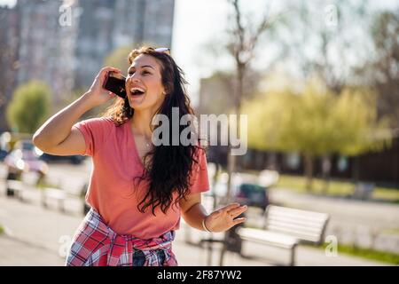 Happy young woman is enjoying sunny day outdoor in city. Stock Photo