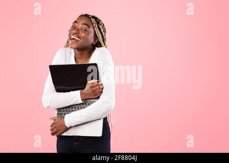 Technology Lover. Excite black woman hugging personal laptop computer Stock Photo