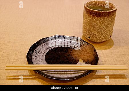 Chopsticks with Plate and a Cup of Japanese Green Tea on Wooden Table Stock Photo