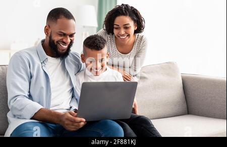 Happy african american family using laptop in living room Stock Photo
