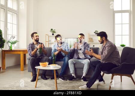 Smiling positive young men friends sitting and playing game with guessing words Stock Photo
