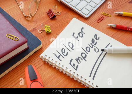 Handwritten sign Help for employee in the white notepad. Stock Photo