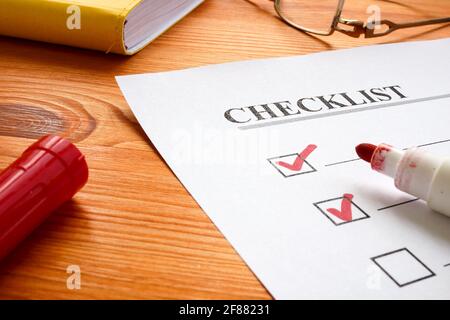 Checklist with marks and red marker on the desk. Stock Photo