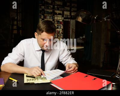 The auditor works late with the report and financial data. Stock Photo