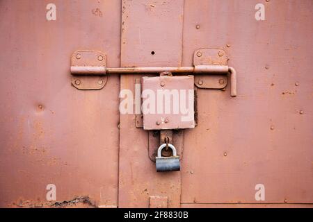 Old lock of the metal door.  Rusty old metal texture with remnants of the paint. Grungy background for any design. Stock Photo