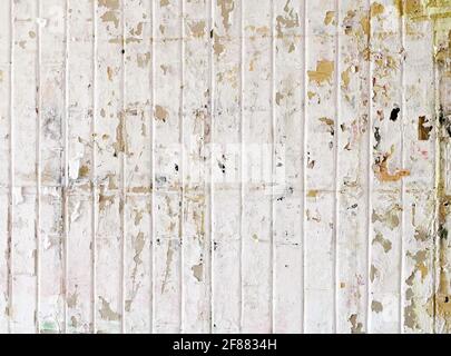 Urban background, white ruined industrial wall with creased crumpled placard. Stock Photo