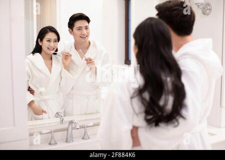 Happy young couple brushing teeth in bathroom Stock Photo