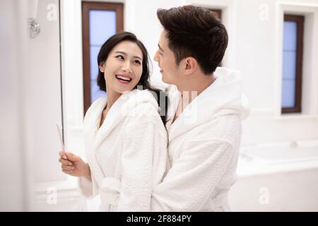 Happy young couple brushing teeth in bathroom Stock Photo