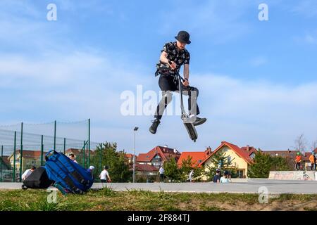 Gdansk, Poland - April 11, 2021: A boy jumping with his scooter and performing a trick Stock Photo