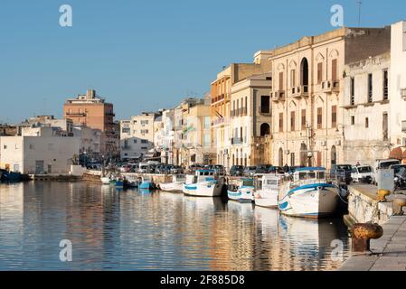 03.21.2021, many old boats are moored on the Mazaro river, at the port of Mazara del Vallo in Sicily, and are reflected in the water Stock Photo