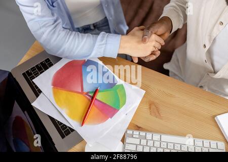 Portrait of multiracial business people shaking hands after successful negotiations, sign a contract. Confident employees having important meeting Stock Photo