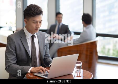 Confident businessman using laptop in coffee shop Stock Photo
