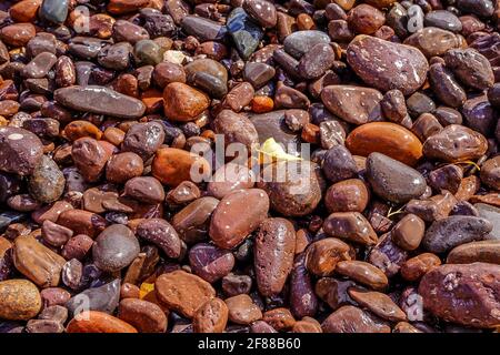 Closeup of colorful beach stones in the waves along the North Shore of Lake Superior in Minnesota Stock Photo