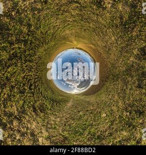 blue sky ball in middle of swirling field. Inversion of tiny planet transformation of spherical panorama 360 degrees. Curvature of space. Stock Photo